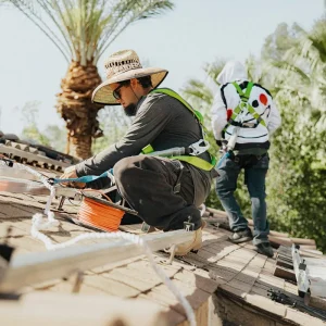 Solar installers working on a residential rooftop during panel installation