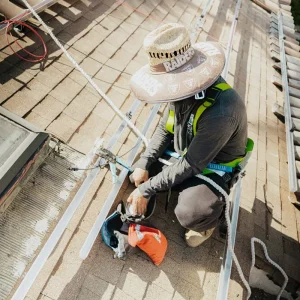 Solar technician installing mounting hardware on a residential rooftop