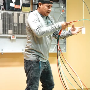 Solar technician preparing electrical cables inside a residential garage