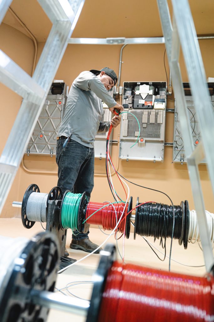 Solar technician installing whole-home backup batteries in a garage